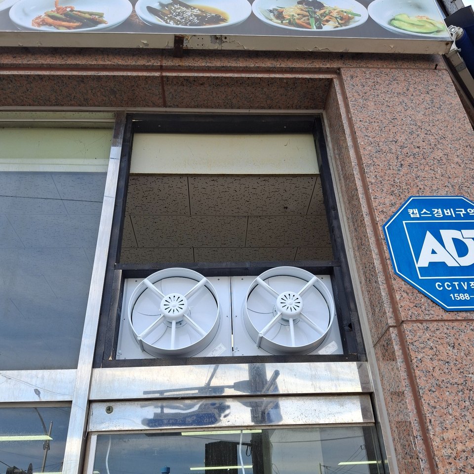 식당 실외기실 창면 상단에 환풍기를 고정한 사진