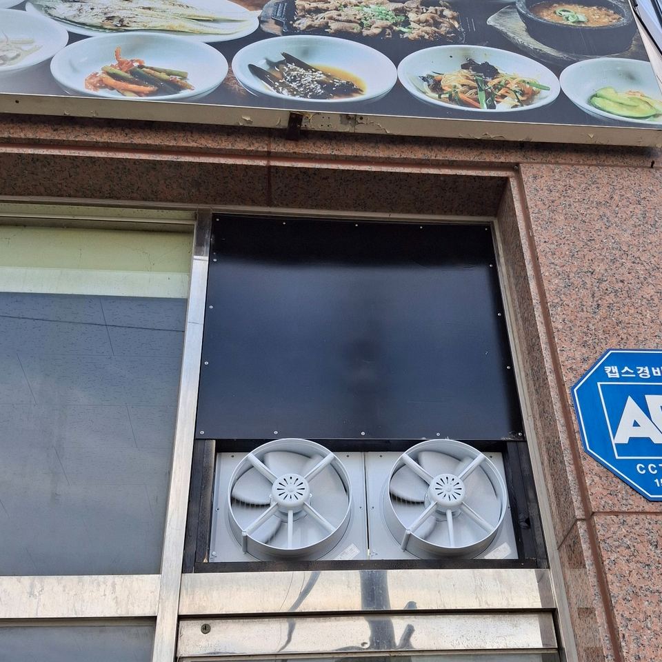 환풍기 2대 위쪽 남는 창면을 검은 패널로 마감한 업소용 환풍기 설치 완료 모습