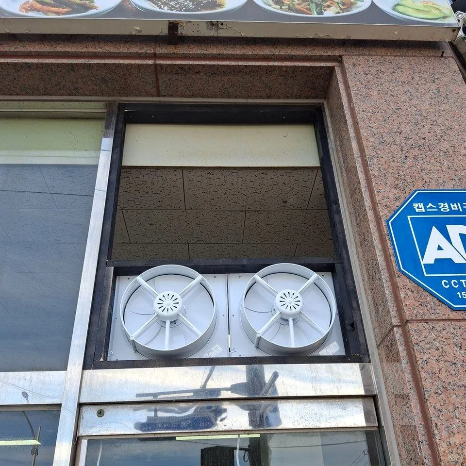 식당 외부 창 상단 프레임에 고정한 환풍기 두 대